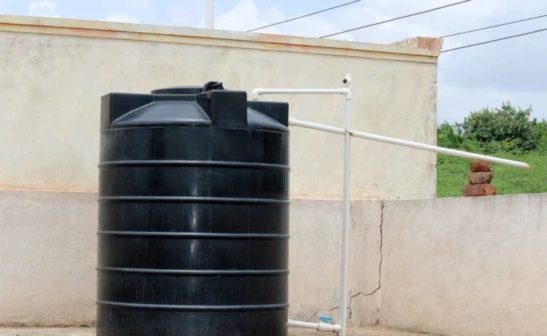A black water storage tank on a rooftop.