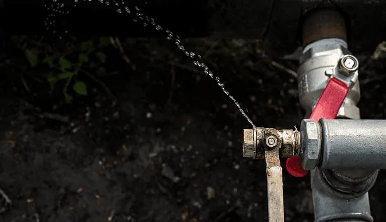 An outdoor tap with water leaking 
