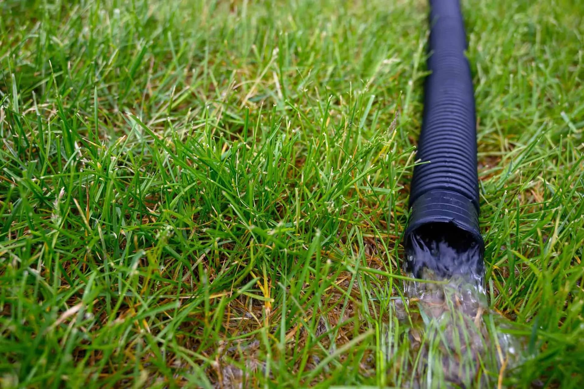 A flexible hose from a residential sump pump carrying water from the flooded basement away from the house
