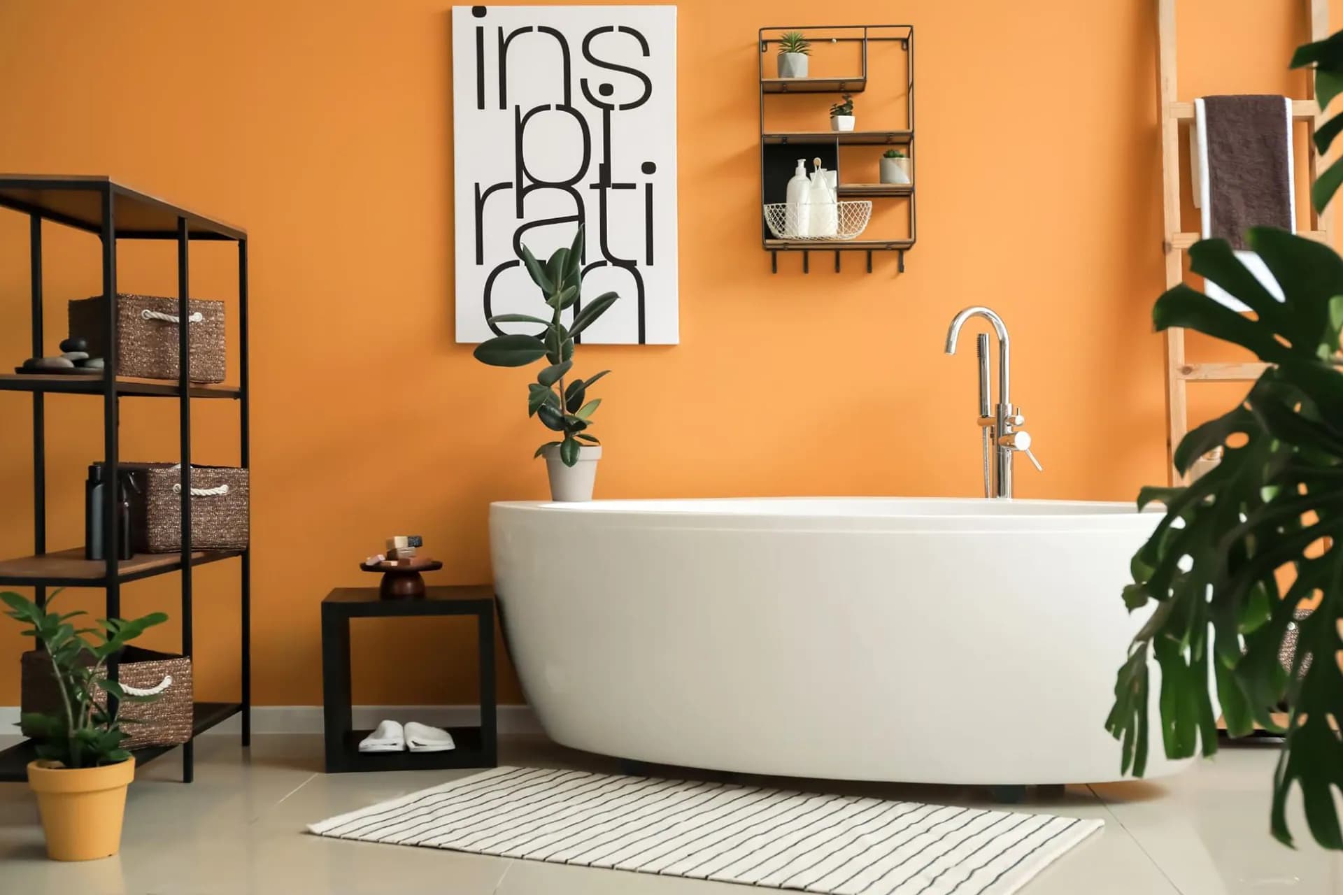 A cast iron bathtub in a bathroom with orange hues