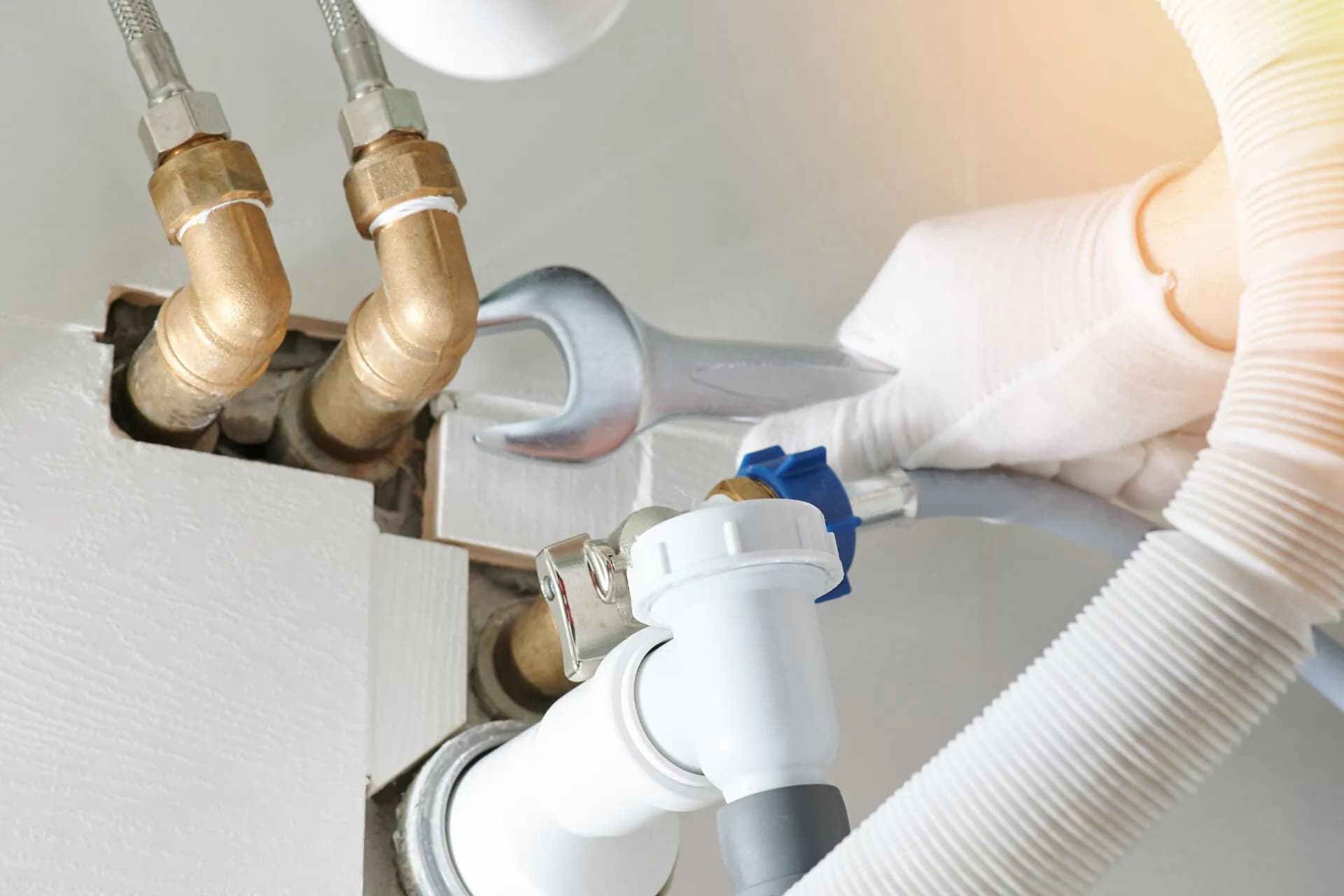 A plumber repairing a drain pipe in a bathroom