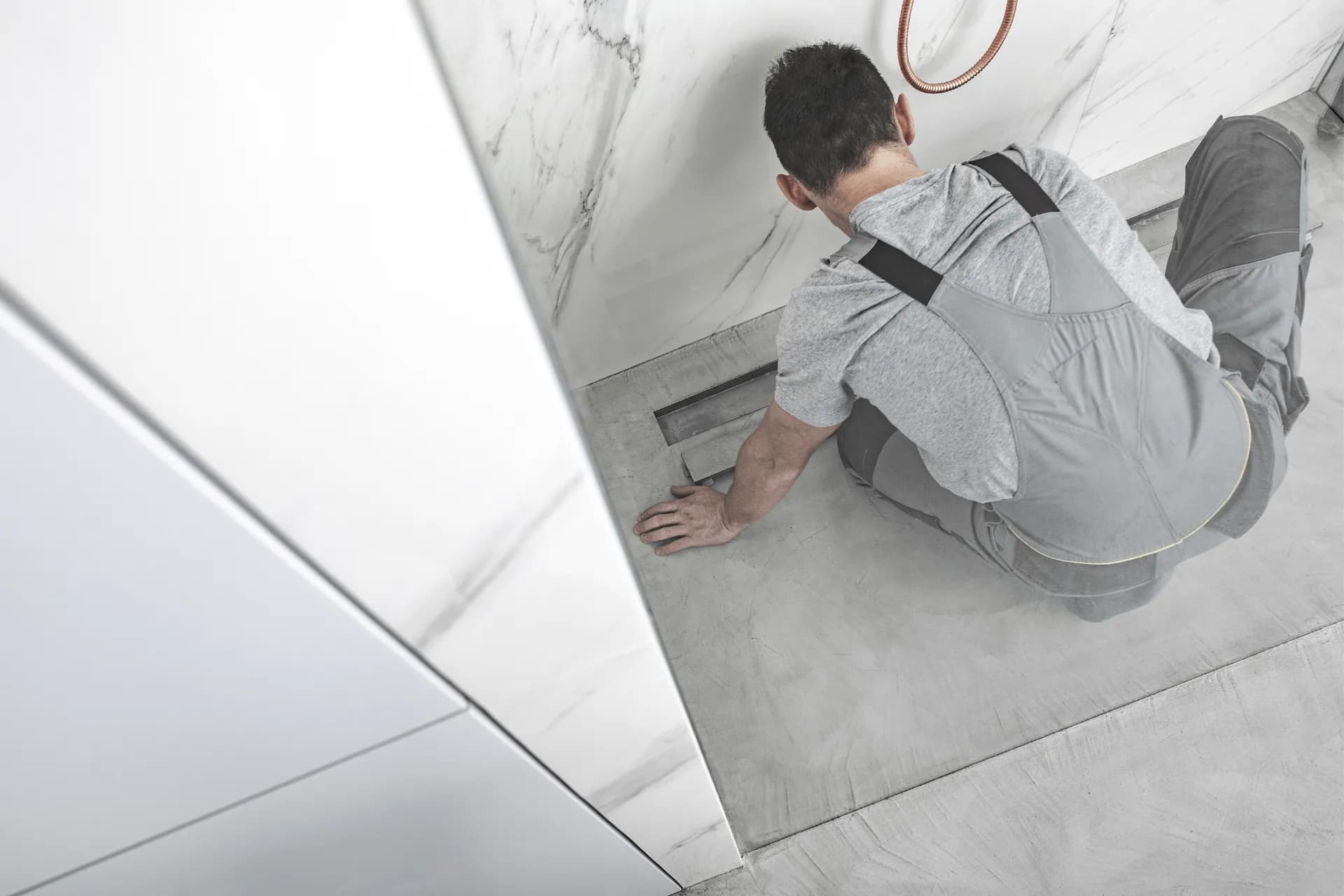 A technician installing a shower drain