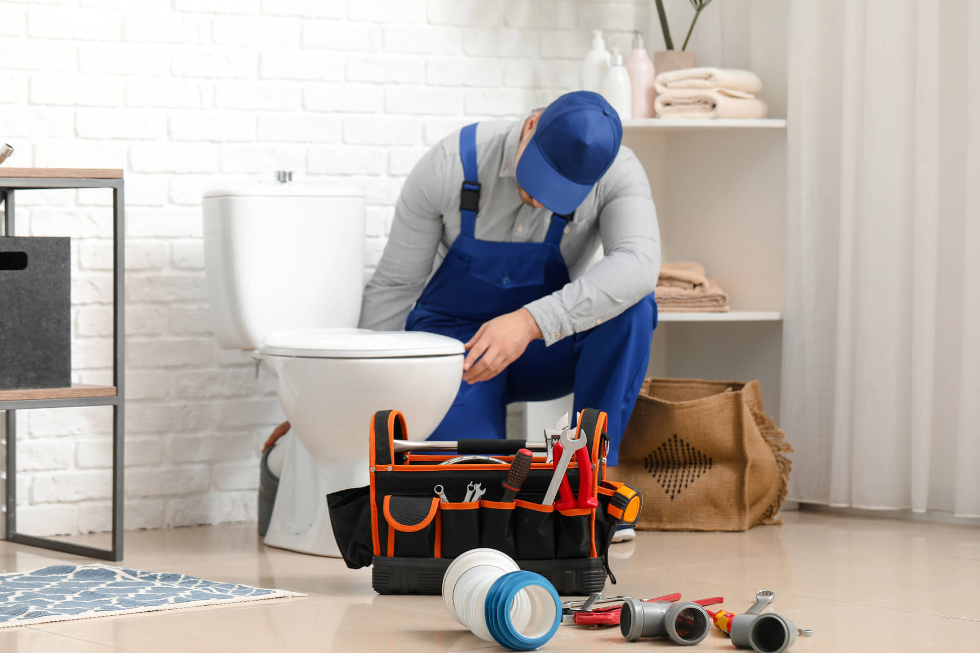 A plumber repairing a toilet seat 