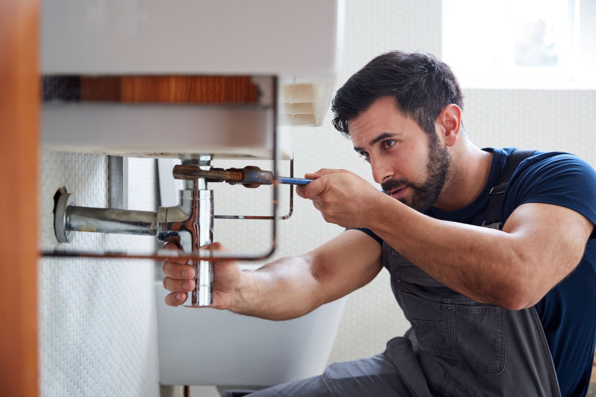 A man using adjustable pipe clamps