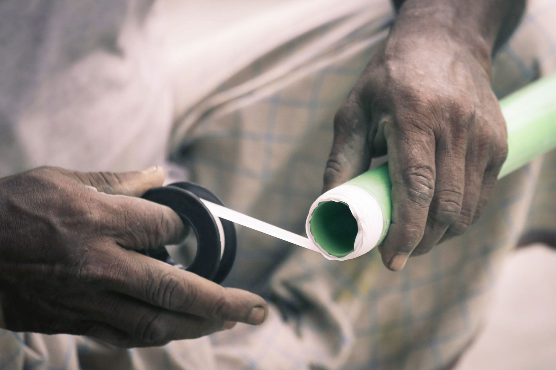  A person uses plumbers’ tape on a PVC pipe 